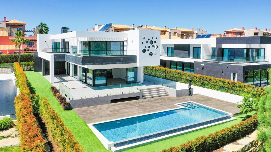 Una gran casa blanca con una piscina delante de ella.